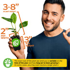 A smiling man holds a Wellspring Gardens White Bat Live Flowering Plant (Tacca integrifolia) in a 2" wide, 3" high pot. Plant height is 3–8", and size may vary.