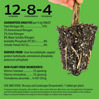 A hand holds a plant with exposed roots and soil against a green background. Text highlights Wellspring Gardens Root Booster Tablets (3-Pack), which reduce transplant shock and improve root establishment for ornamentals.