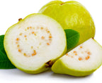 A whole Peruvian White Guava (Goiaba, Araçá-goiaba) by Wellspring Gardens is displayed with a halved piece and a wedge, showing white flesh and small seeds. Green leaves are visible beneath the fruit. Scientific name: Psidium guajava.