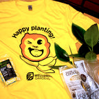 The Mekong Monkey 'Happy planting!' T-shirt by Wellspring Gardens features a bright yellow color, a winking cartoon plant face, cheerful text, and the playful gardening mascot. Perfect for plant lovers!.