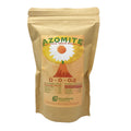 A brown paper bag labeled AZOMITE Organic Trace Minerals—Derived from Volcanic Ash (14-OZ or 2-LB) by Wellspring Gardens. The label features a flower graphic, micronized minerals, NPK values, and the Wellspring Gardens logo at the bottom.