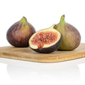 Three GE Neri (Italian) figs from Wellspring Gardens, two whole and one halved to show its red, seedy interior, rest on a wooden cutting board with a white background highlighting the figs and the board.