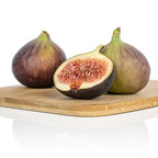 Three GE Neri (Italian) figs from Wellspring Gardens, two whole and one halved to show its red, seedy interior, rest on a wooden cutting board with a white background highlighting the figs and the board.
